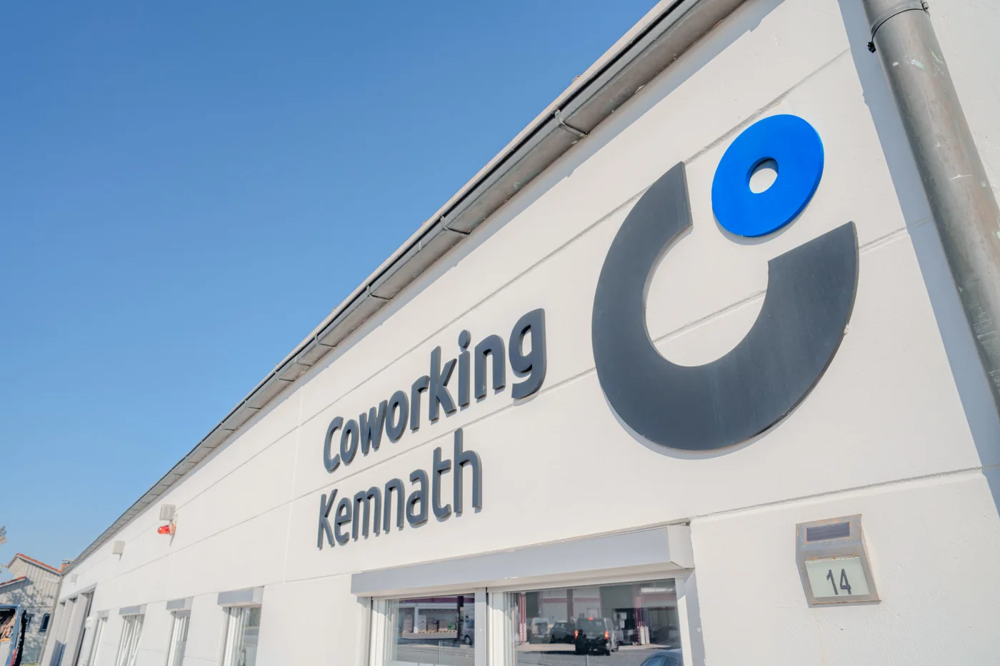 Fassade des Coworking Kemnath mit Schriftzug und Logo vor blauem Himmel
